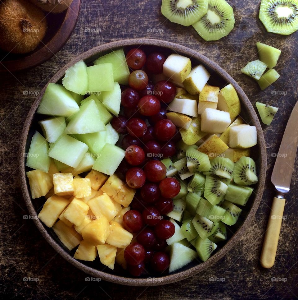 Fresh fruit salad platter with kiwi, grapes, pineapple and cantaloupe.