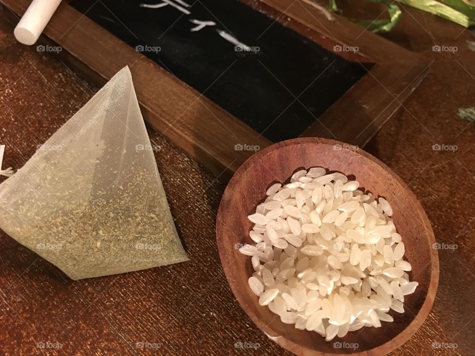 High angle view closeup of green tea bag with bowl of rice preparing healthy food and drink 