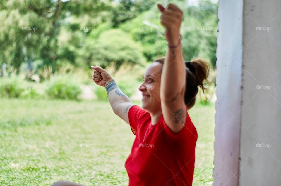 woman smiling happily and raising her arms on a Sunny day