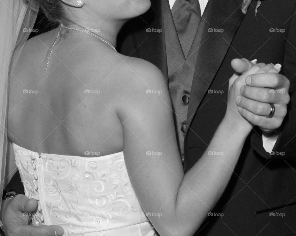 Holding hands; black and white close up newlyweds first dance