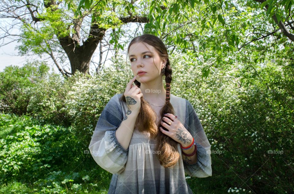 Portrait of Young Girl on Background of Flowers