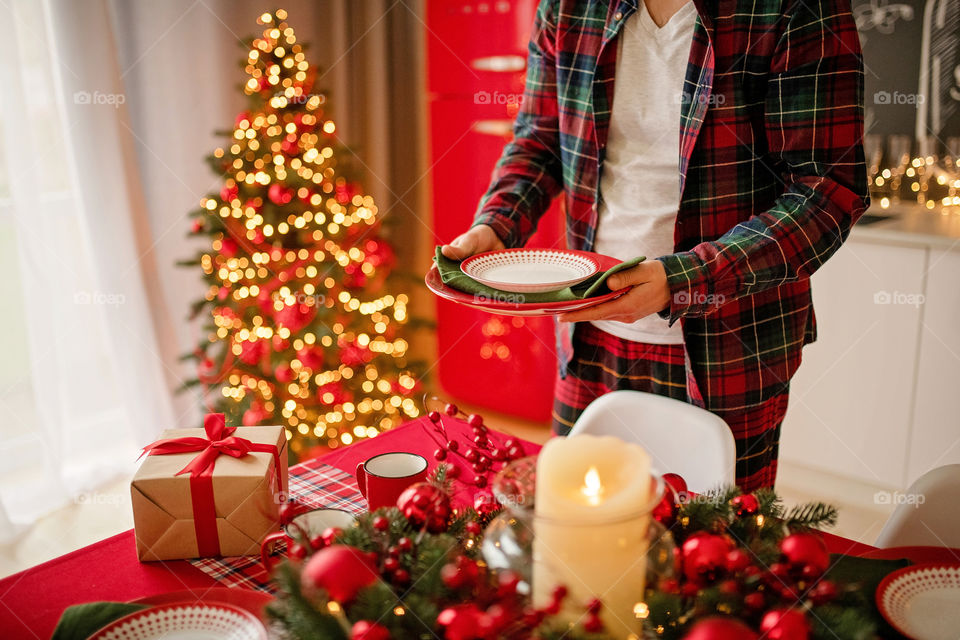 man sets a beautiful decorated winter table for a festive dinner.  Merry Christmas and Happy New Year.