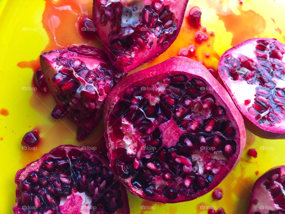 Cut pomegranates on yellow