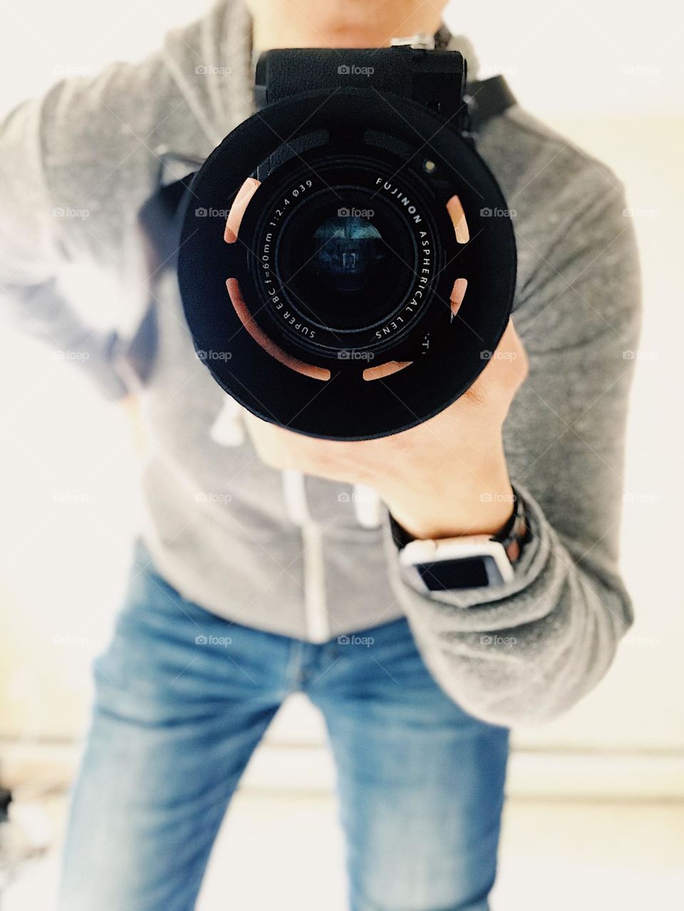 Photographer focuses on subject, using a Fujifilm camera, focusing photographer, view from the subject 