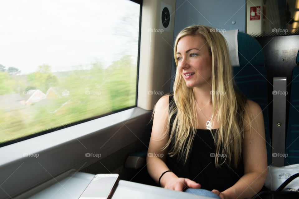 Woman looking out the window on the train from Gatwick Airport to London.