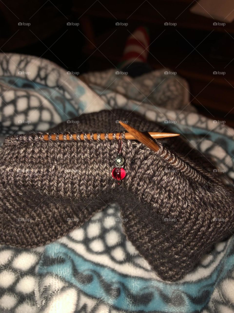 Brown knitwear in progress with red jewel stitch marker jewelry 