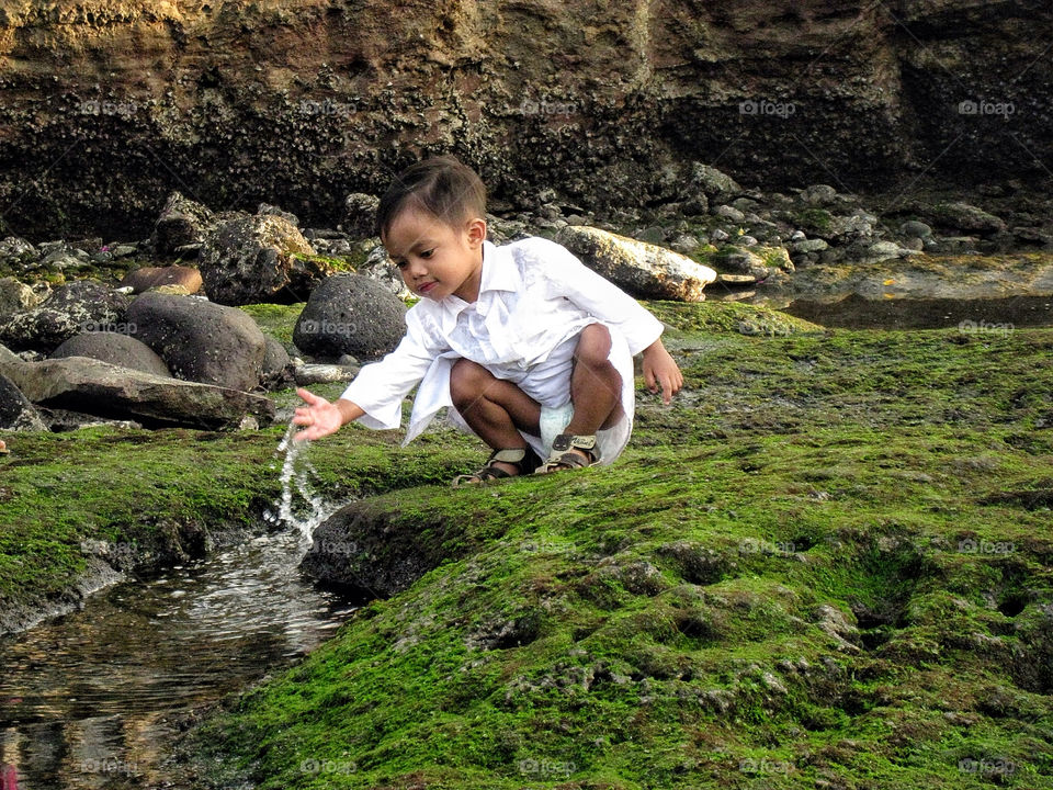 Balinese boy playing with river water