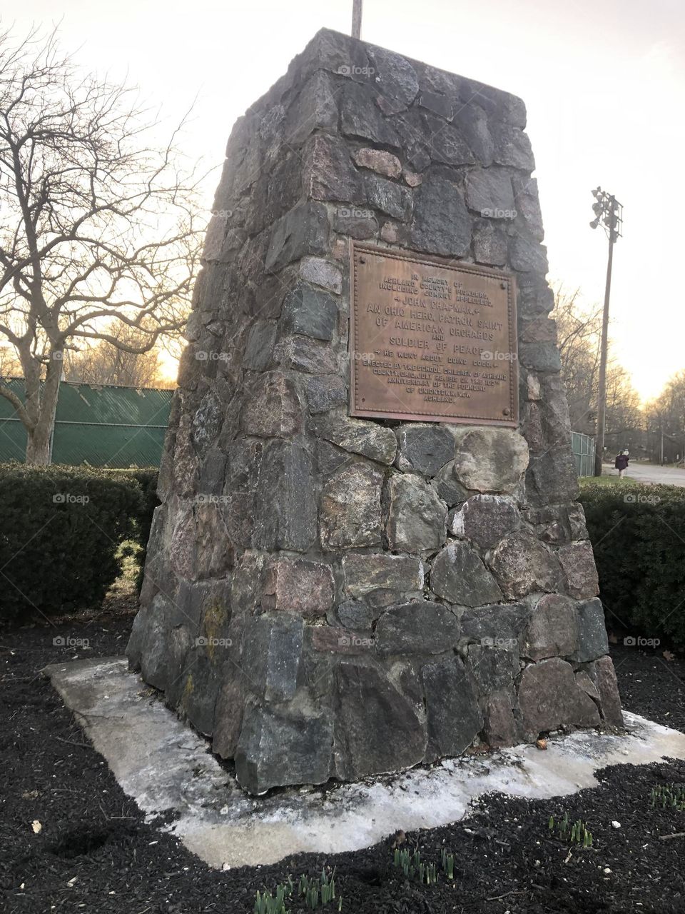 Monument in the park surrounded by bushes and made of large stones 