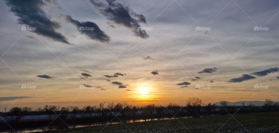 Epic view of river, field near by it and sky in pastel colors during beautiful sunset