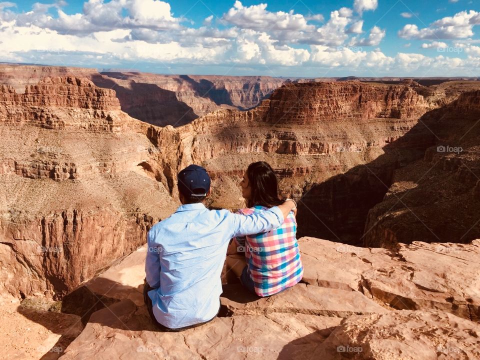 Couple Grand Canyon together sitting USA desert looking over the edge