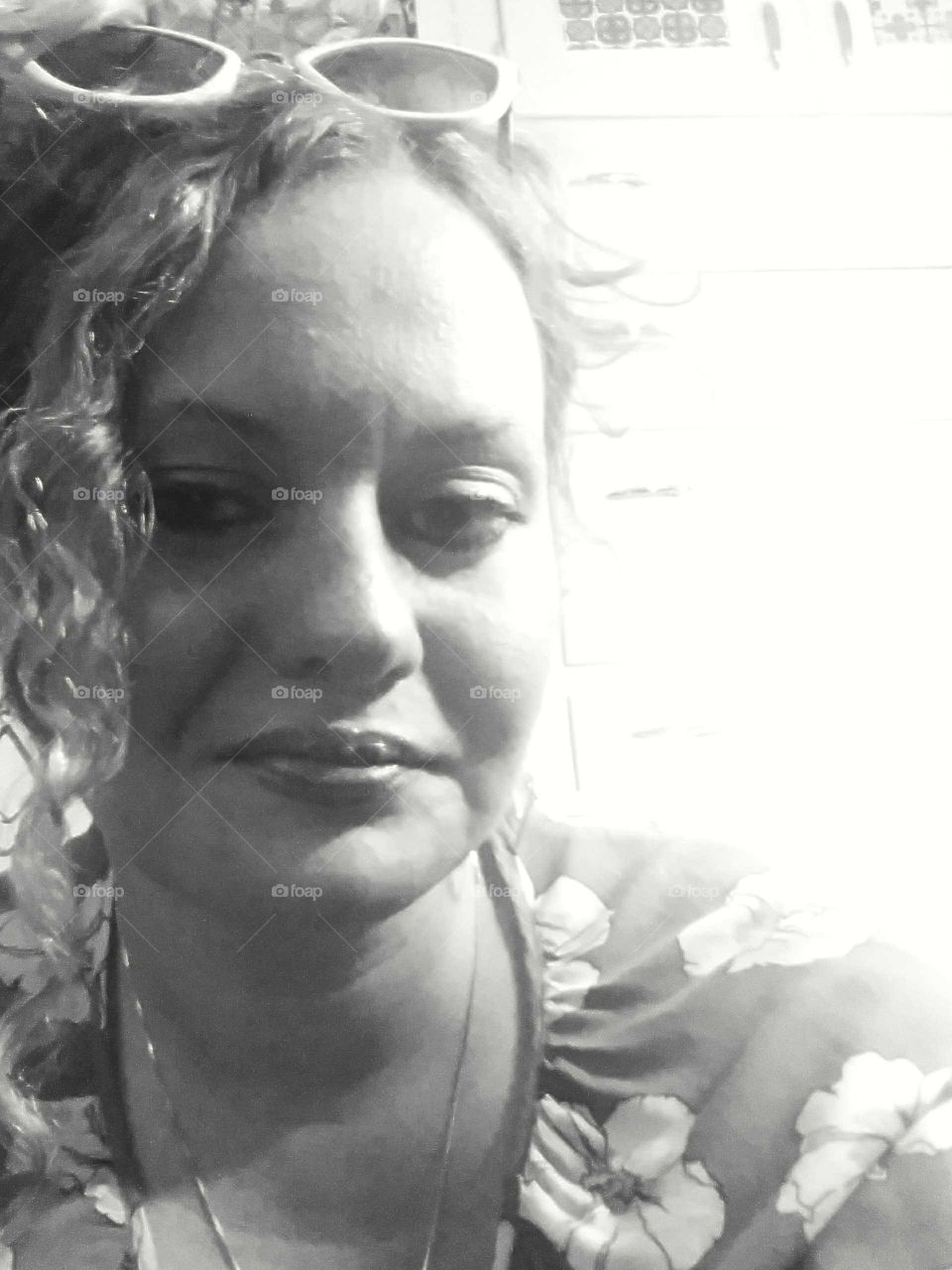 Woman with curly hair smiling a bit.