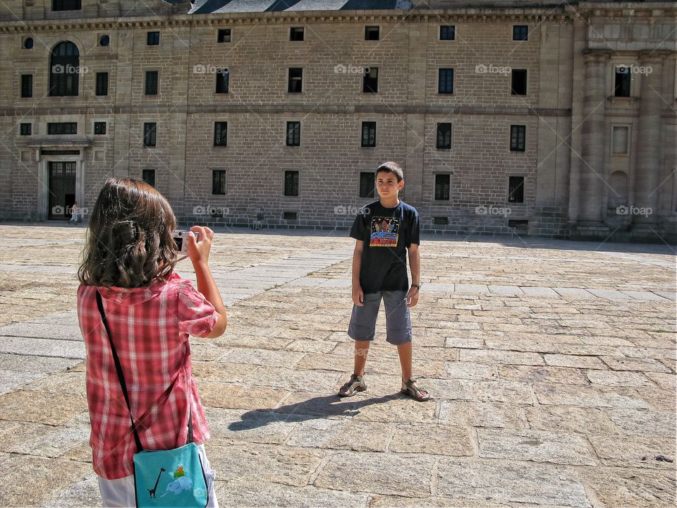 A little girl taking photos of her brother 