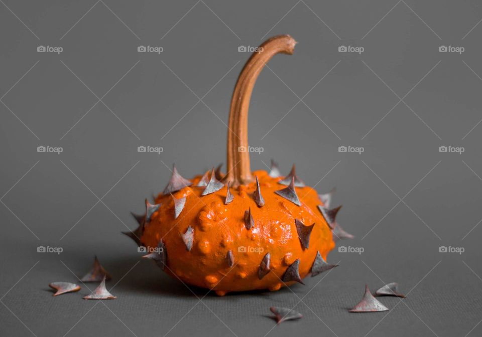 A pumpkin with spikes on grey background