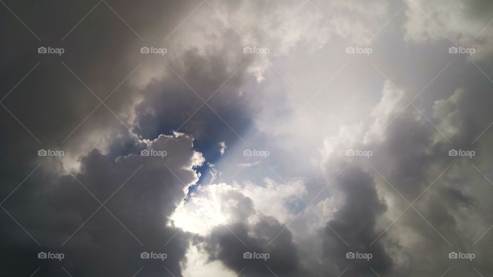 Sun shining through clouded skies