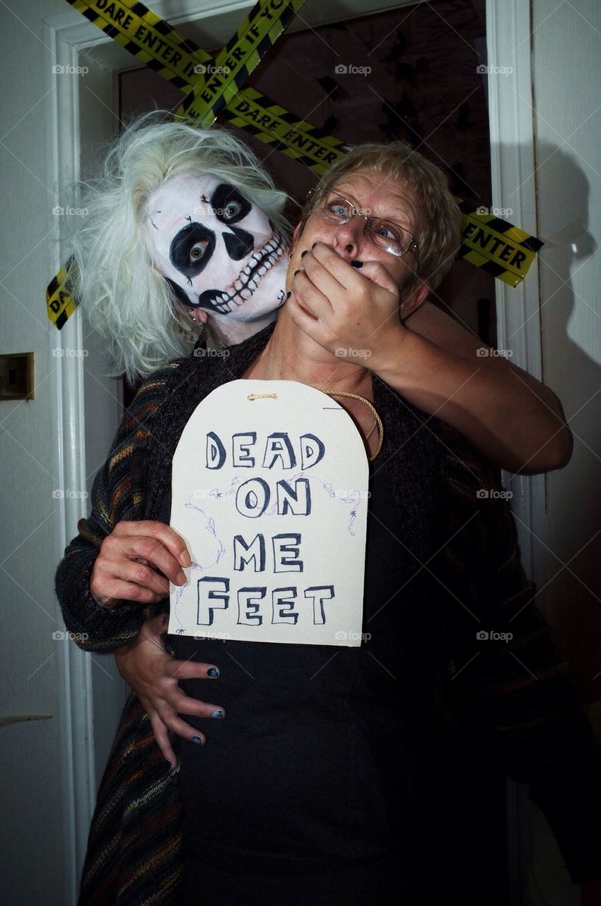 A young woman in Halloween face paint in the style of a skull between