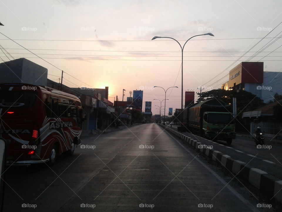 the sun sets in the city of tegal