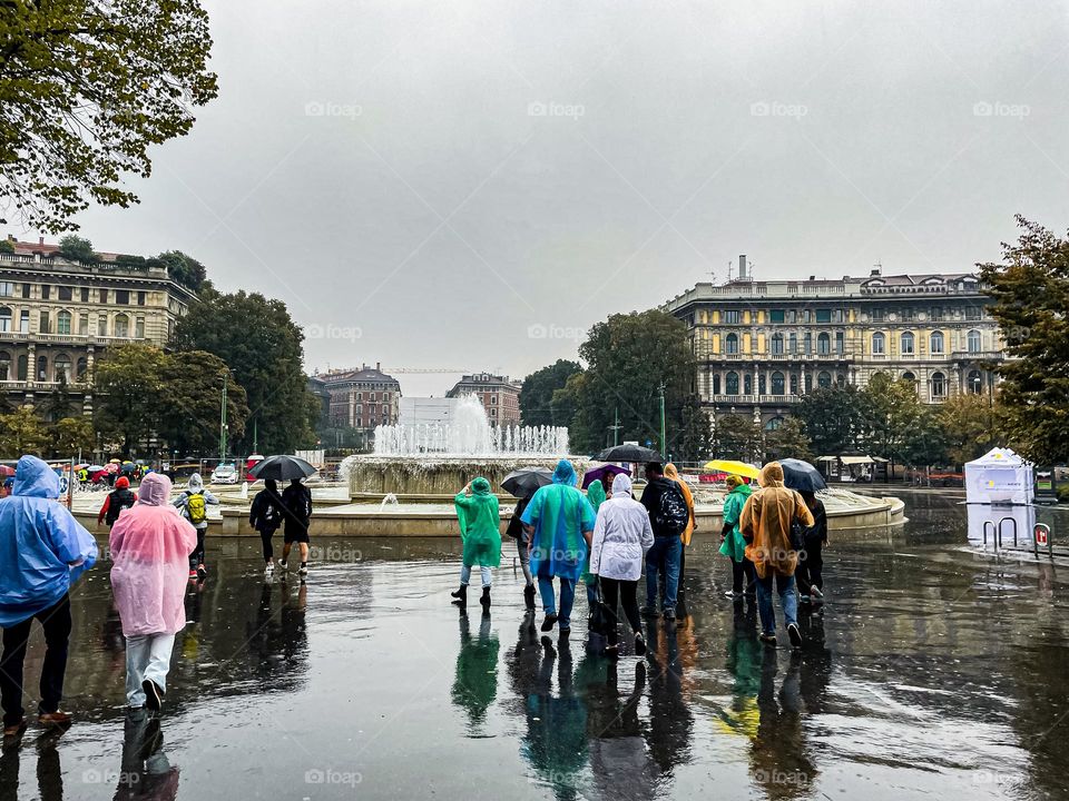 Crowds of people walking down the street on a rainy day.