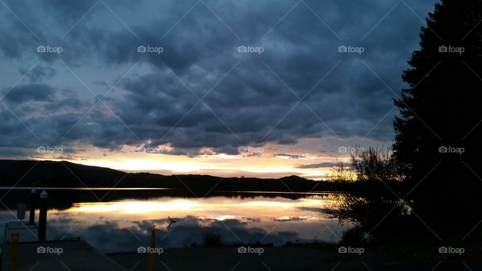 dark clouds shot Sunset with dramatic clouds reflected in lake