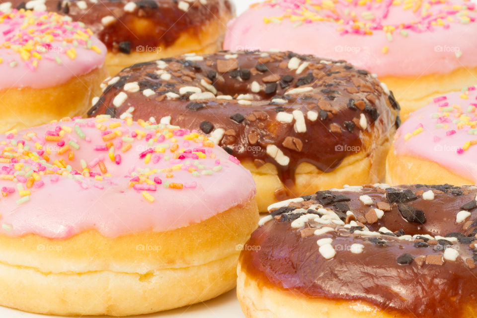 Lots of chocolate and pink iced donuts.