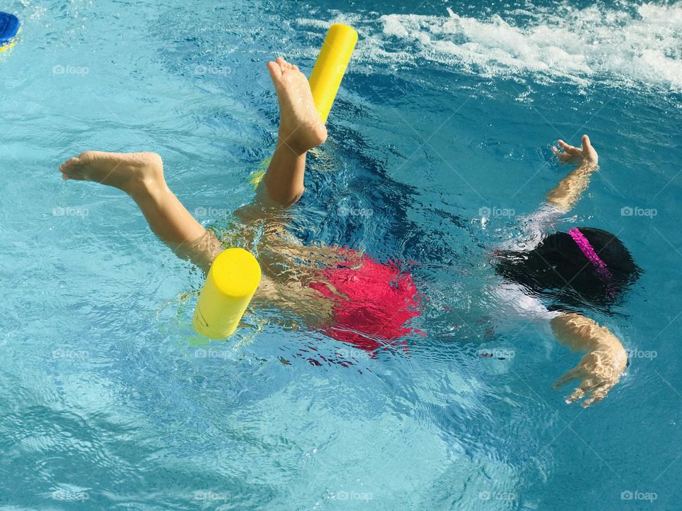 A girl having fun at outdoor swimming pool at summer time.