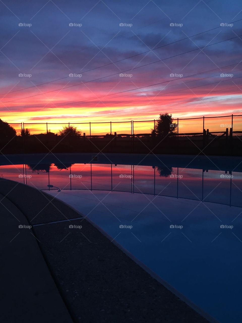 Pink purple yellow sunset sky swimming pool reflection