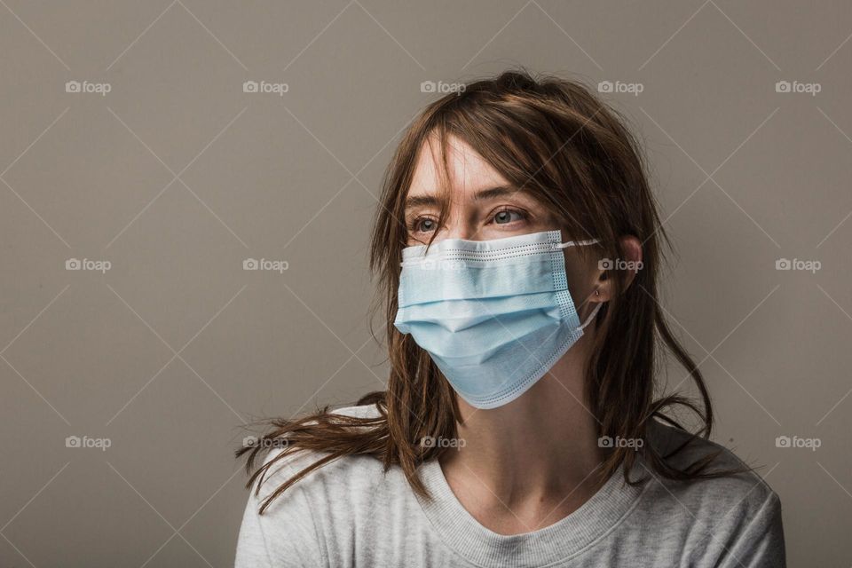 A lady putting on a nose mask