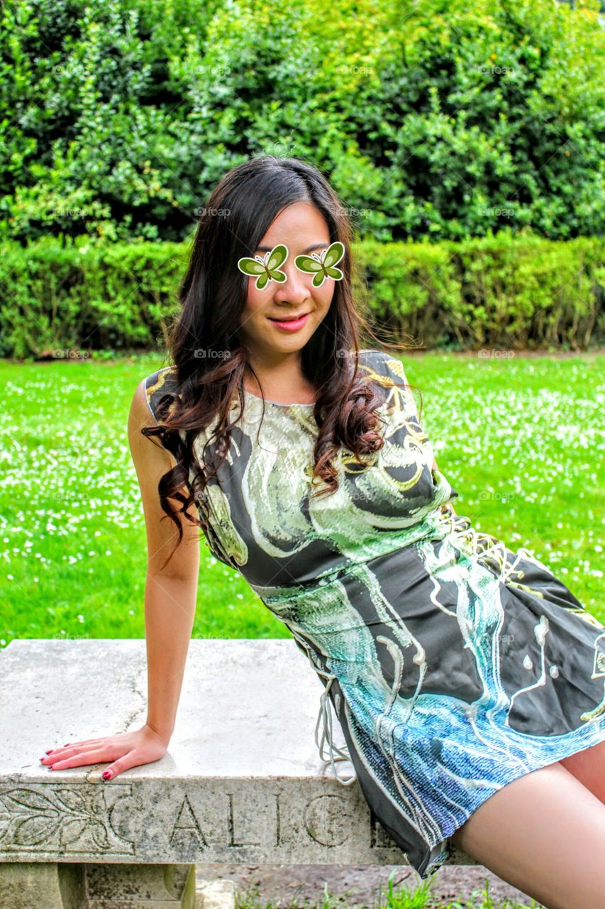 model posing on a stone park bench