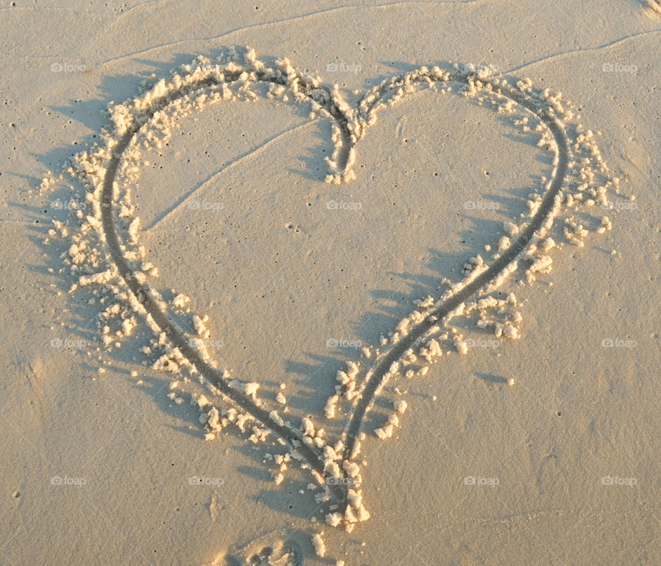 A heart drawn in the sand at the beach