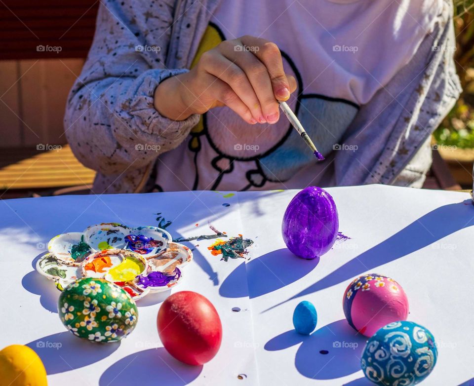 Girl painting Easter egg.