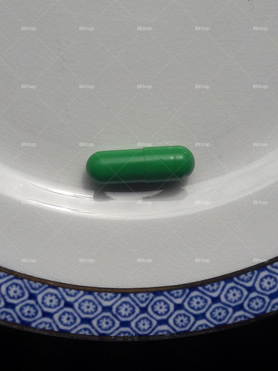 my green medical pill on a chinaware plate
