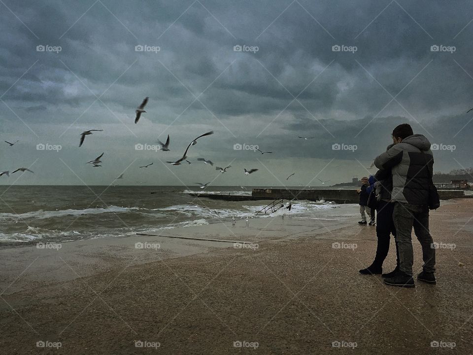 Storm sea, seagulls and couple 