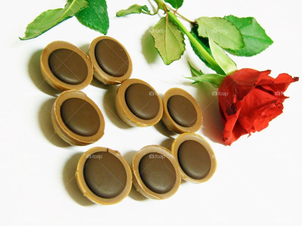 Chocolate with rose flower on white background