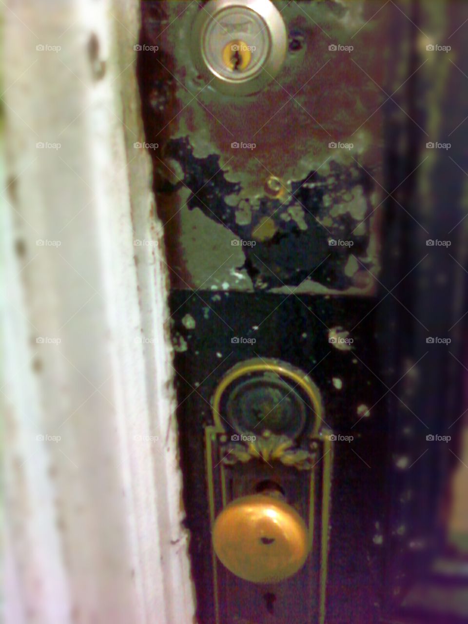 Rustic door knob and lock on antique Brownstone door, New York City