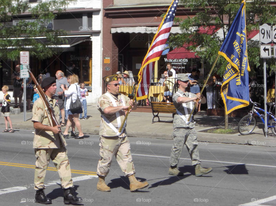 Military men marching in a July 4th parade.
