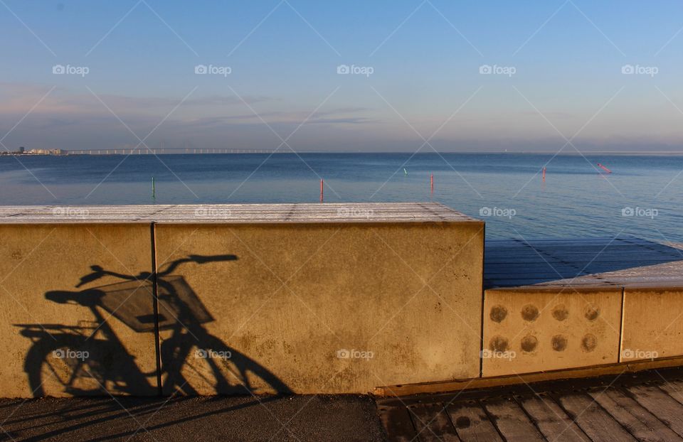 Bike shadow, winter coming by the ocean.