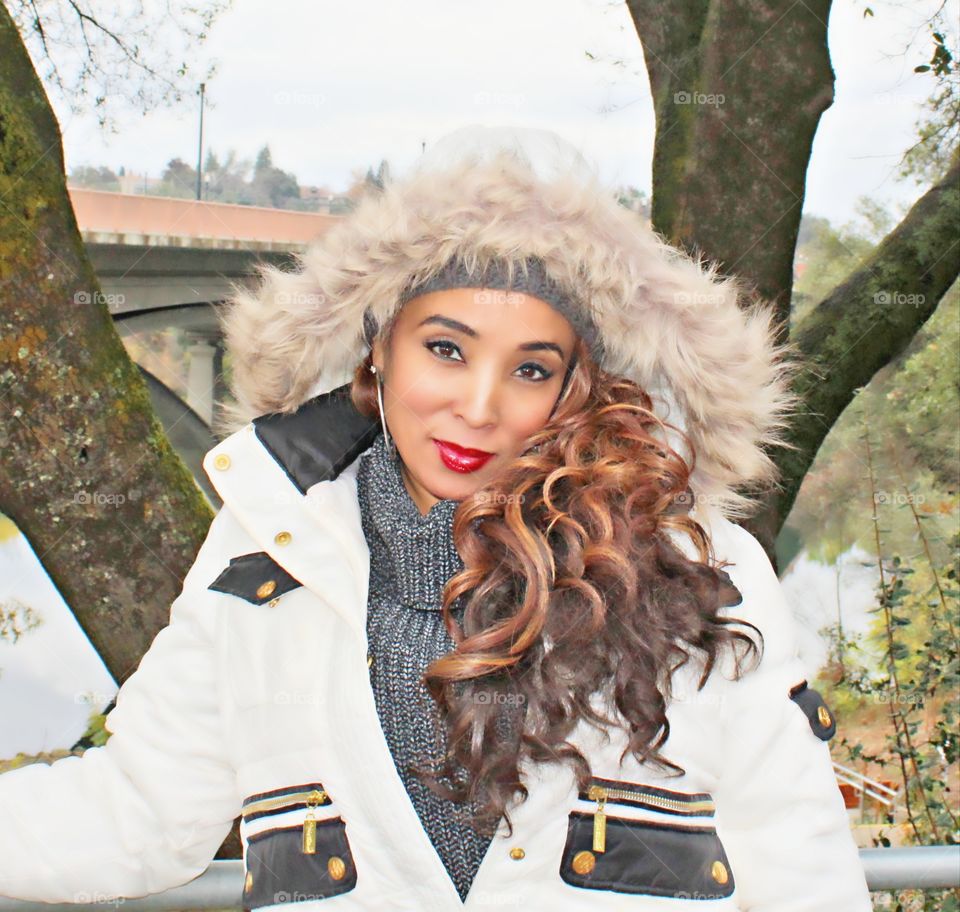 modeling fashion in the outdoors with a bridge in the background