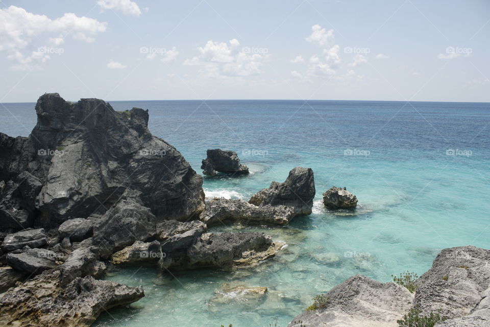 Vivid Ocean Cliffs of Bermuda. Aquamarine waters surround rocky cliffs on this island beach. Taken May 2014.
