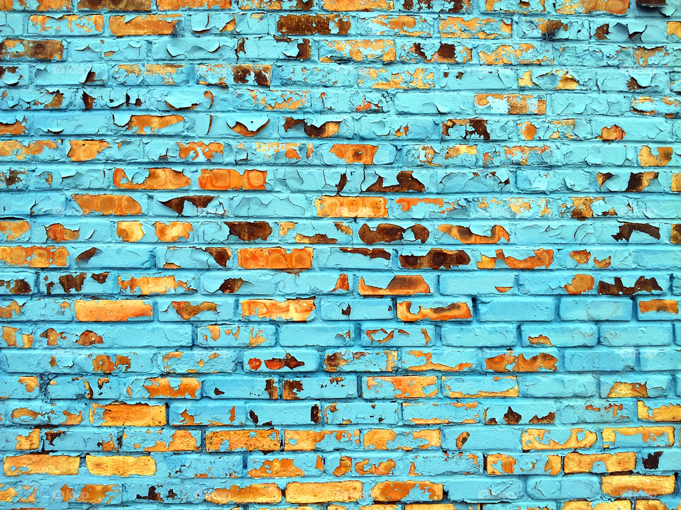 Brick wall with blue paint chipping off
