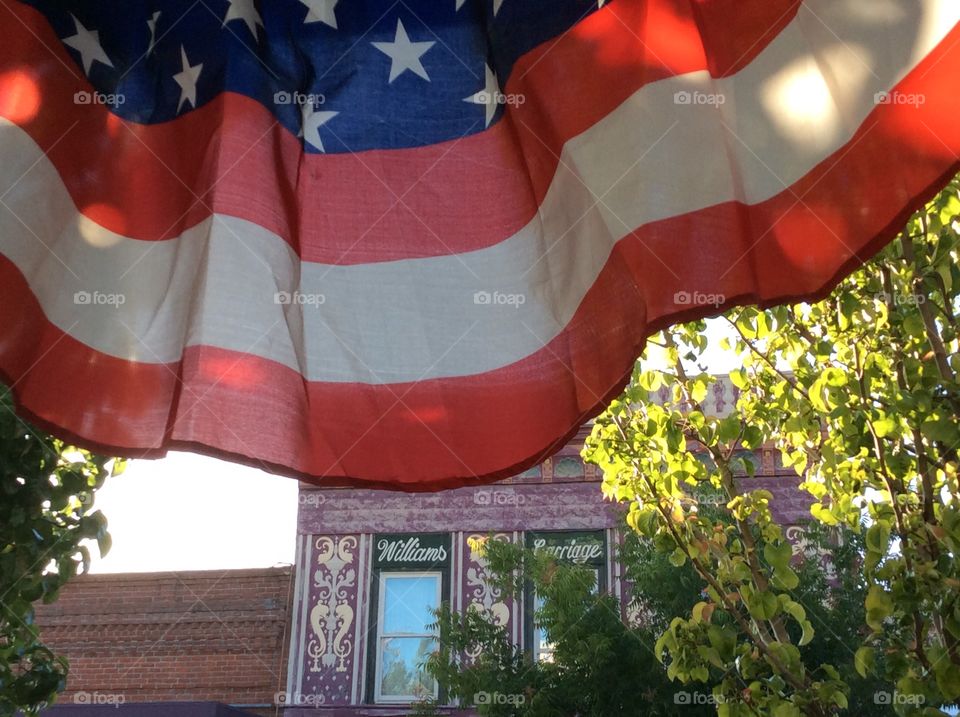 Red white blue Stars and Stripes banner flag hanging in small town 