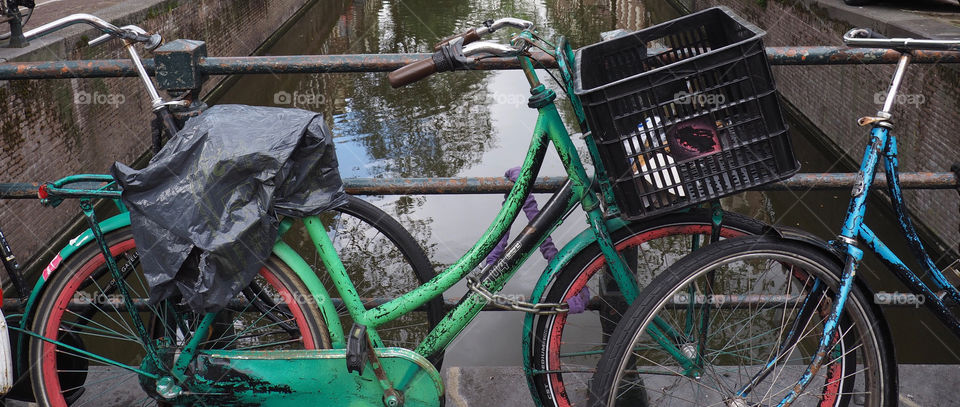 Close-up bikes on rainy day near canal in Amsterdam