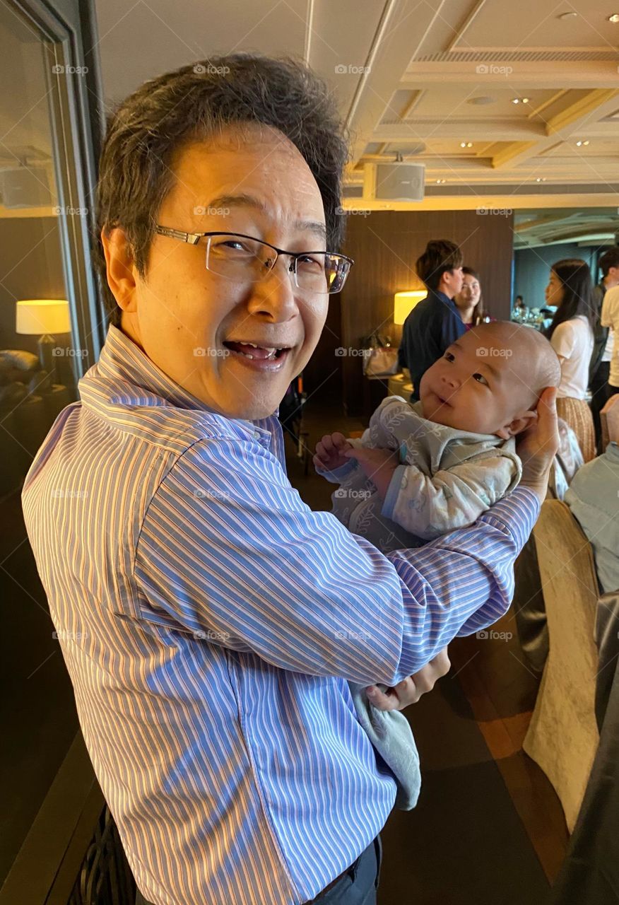 Nice men -- A man holding a smiling baby.