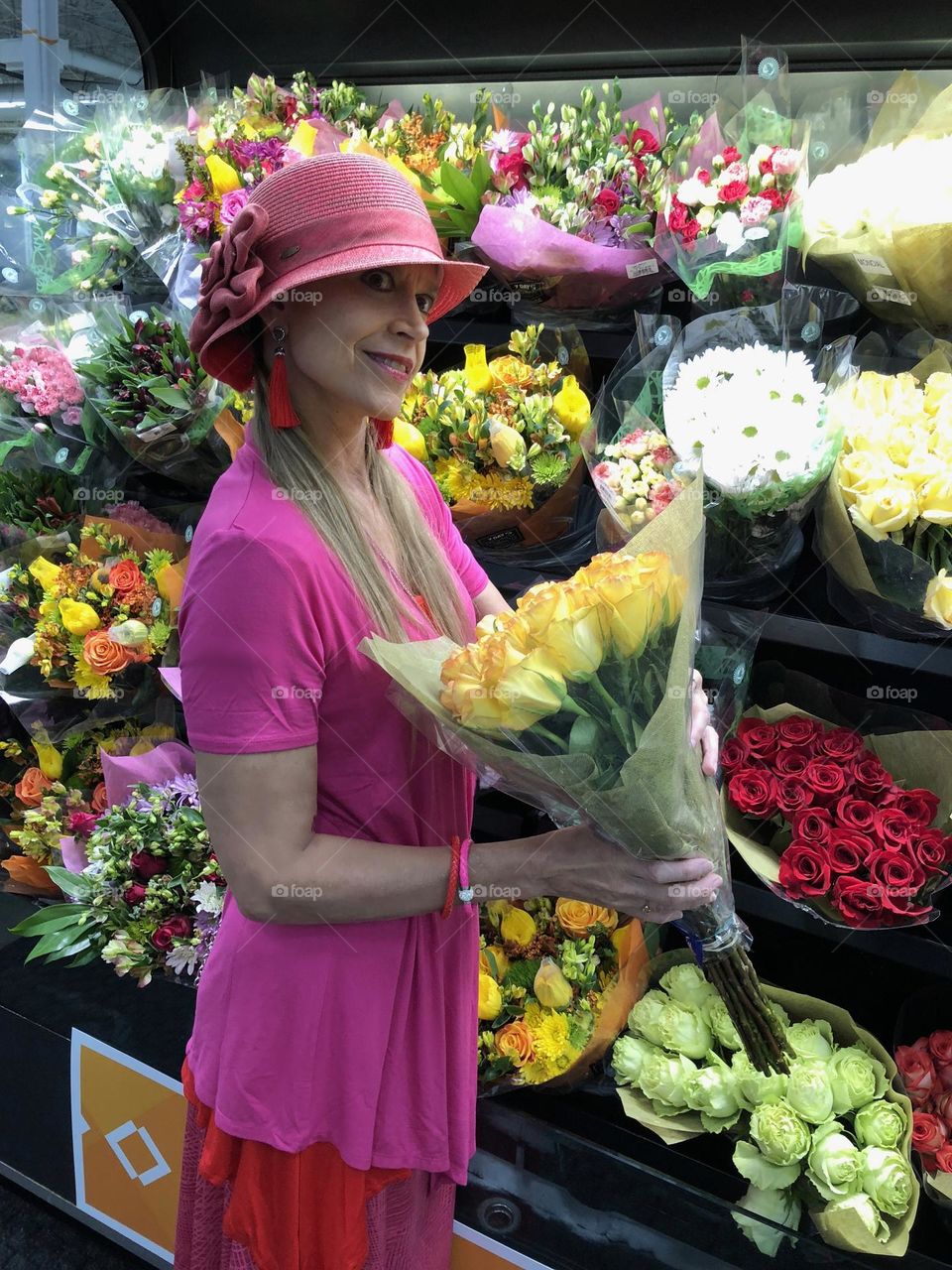 Woman in colorful clothes selecting roses.