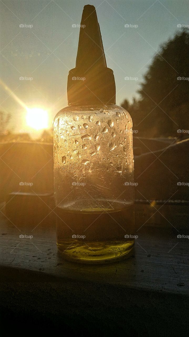 vape liquid with a sunset behind it