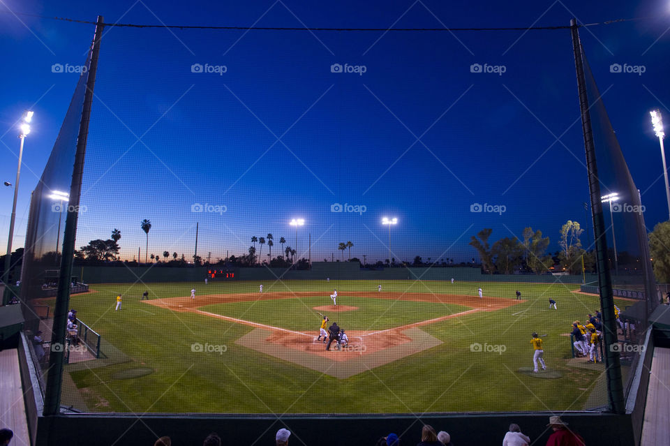 Two baseball teams play as the sun goes down in Arizona.