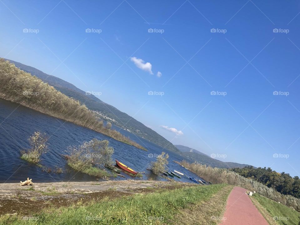 Sunny day by the lake litre trips in Europe Poland. Beautiful blue sky and water, few boats and kayaks by the shore. 