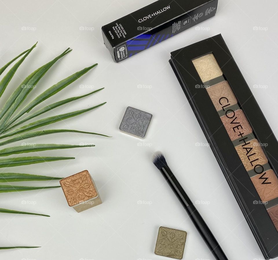 Eye shadow flat lay with palm leaf