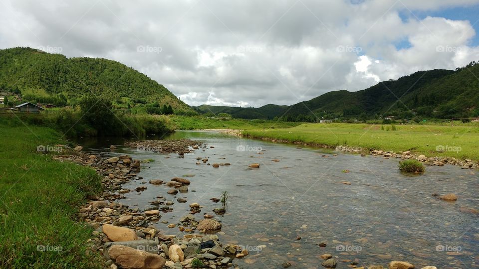 Scenic view of hill with stream