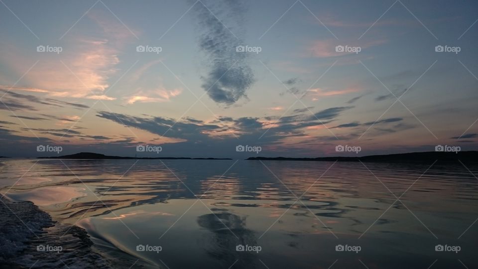 cloudy sky at sunset reflecting in the sea