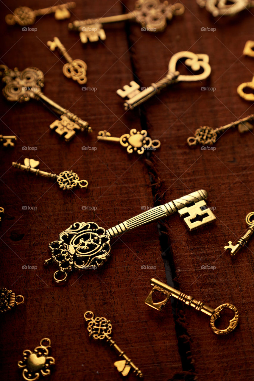 Golden antique keys on wooden background