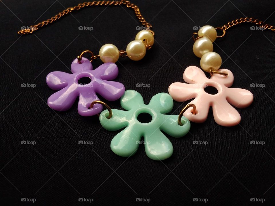 women's accessories in the form of necklaces from chains with flower decorations made of plastic and other beads.